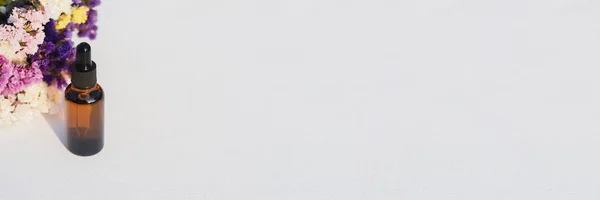 Amber Skleněné Kapátko Láhev Bílém Pozadí Suchými Květy Kontejner Kosmetickým — Stock fotografie