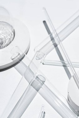 Laboratuvarda beyaz arka plandaki deney tüpleri, petri kabı ve cam çubuklar. Bilim araştırması. Laboratuvar camları yakın çekim. Şeffaf konteynır. Tıp ve güzellik konsepti.