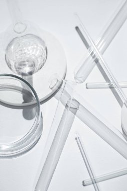 Laboratuvarda beyaz arka plandaki deney tüpleri, petri kabı ve cam çubuklar. Bilim araştırması. Laboratuvar camları yakın çekim. Şeffaf konteynır. Tıp ve güzellik konsepti.
