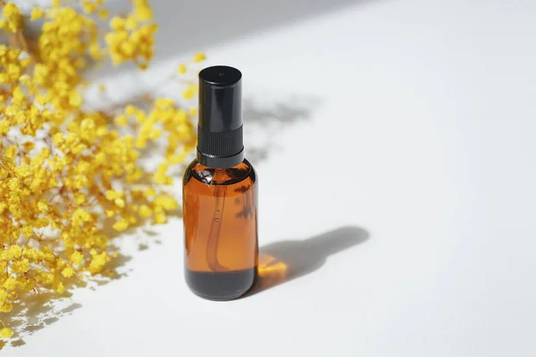 Amber Pump Bottle Serum Tonic Essential Oil Yellow Flowers White — Stock Fotó