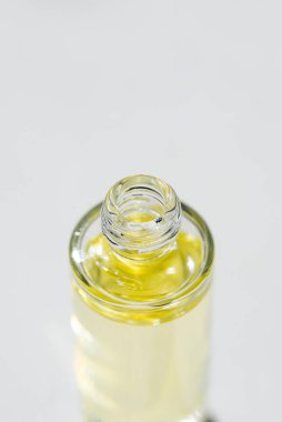 Şeffaf şişeyi serumla kapaksız açın ya da yumuşak odaklı gerekli yağla. Beyaz arka plan, gün ışığı ve güzel gölgeler. Yüz ve vücut bakımı için güzellik konsepti