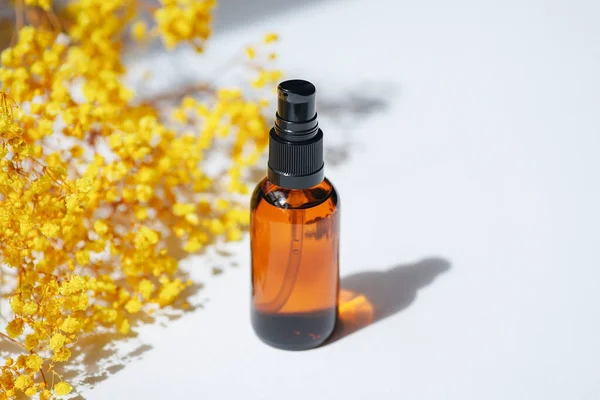 Amber Pump Bottle Serum Tonic Essential Oil Yellow Flowers White — Stock Fotó