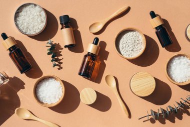 Skincare natural cosmetic. Beauty concept for face and body care. Eco friendly packaging. Amber glass bottles different sizes with bamboo lid. Zero waste concept. Top view on beige background.