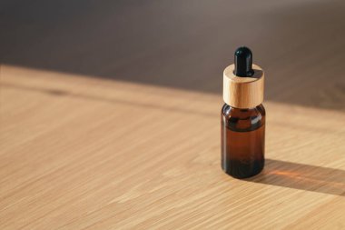 Kehribar şişesi serumla ya da ahşap masada gerekli yağla. Sakinleştirici cbd yağı. Alternatif tıp. Yüz ve vücut bakımı için güzellik konsepti.