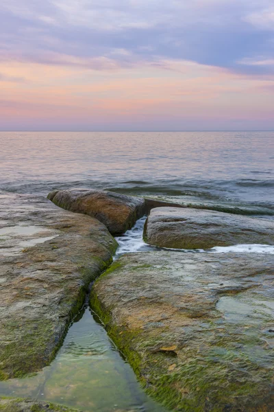 Камни в воде на закате — стоковое фото