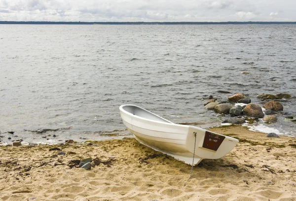 Bílá loď na písku u moře — Stock fotografie