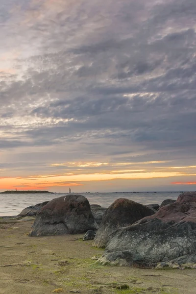 Zonsondergang op zee, rotsen op voorgrond vóór zee — Stockfoto