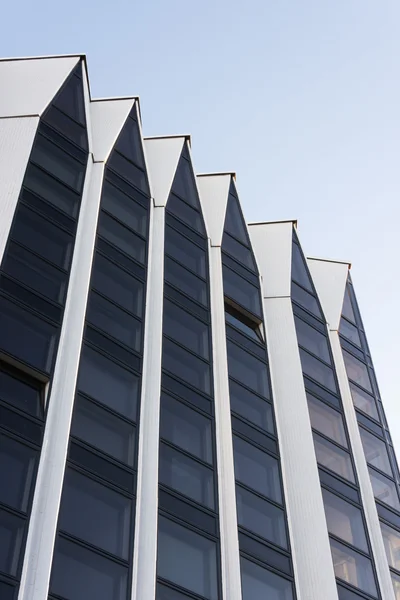 现代建筑的高大的白墙和深色玻璃建筑与三角形形状顶部 — 图库照片
