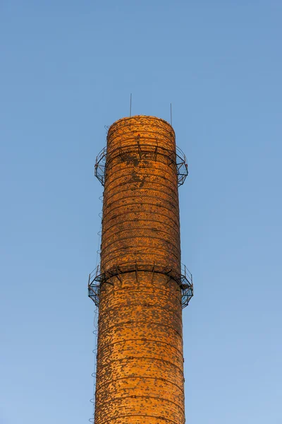 Red brick chimney on blue sky background — Stock Photo, Image