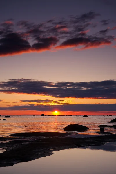 Beau coucher de soleil en mer, gros rochers au premier plan — Photo