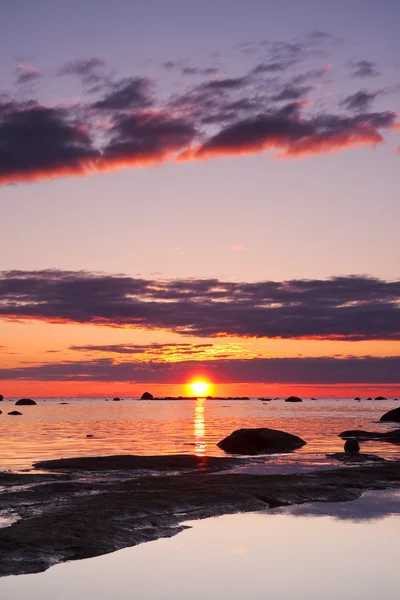 Beau coucher de soleil en mer, gros rochers au premier plan — Photo