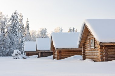 Small camping houses at snowy winter day clipart