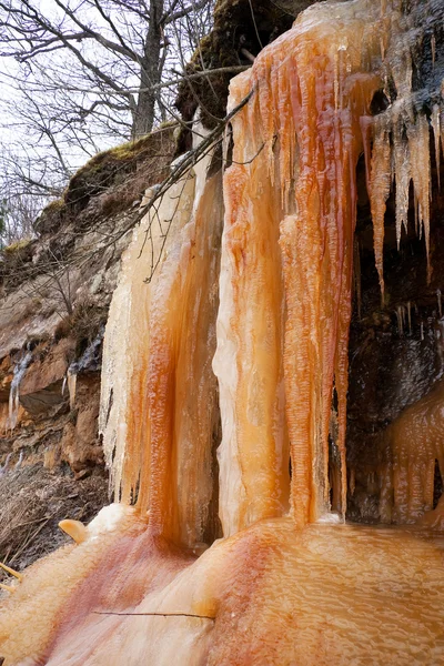 Tall orange icicles on a cliff — Stock Photo, Image