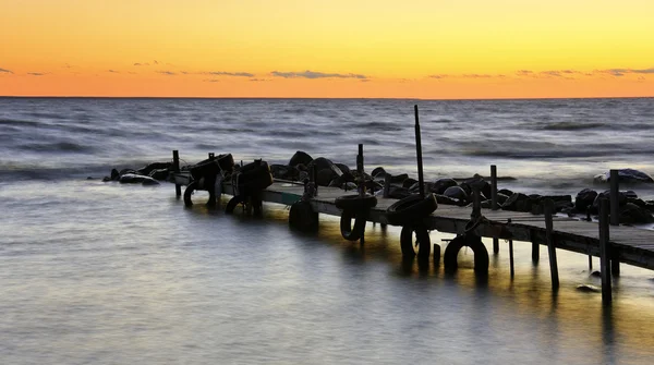 Solnedgången i havet bakom båten bro — Stockfoto