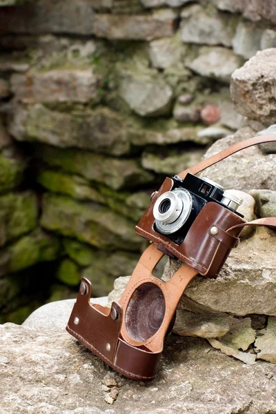 Old camera on rocks — Stock Photo, Image