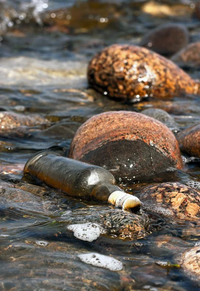 Forgotten bottle on rocks — Stock Photo, Image