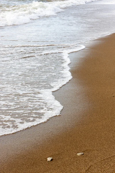 Foamy water waves on brown sand — Stock Photo, Image