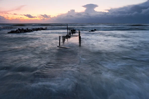 Dřevěný most v moři při západu slunce — Stock fotografie