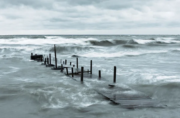 Dřevěný most v rozbouřeném moři — Stock fotografie