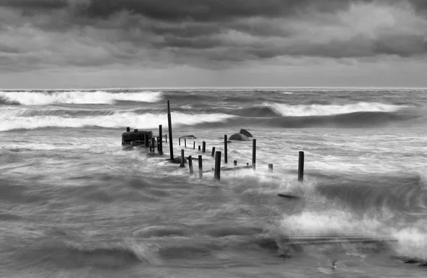 Houten brug in stormachtige zee — Stockfoto