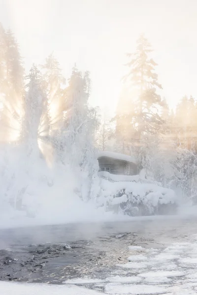 Cabaña cerca del agua y el bosque brumoso en invierno —  Fotos de Stock
