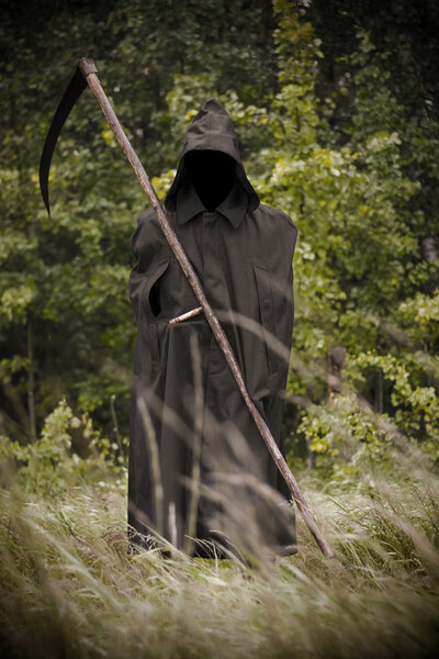 Death standing with scythe on hand