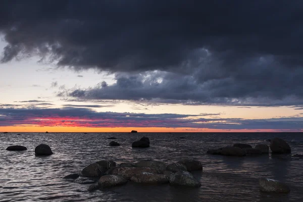 Sonnenuntergang am Meer voller Felsen — Stockfoto