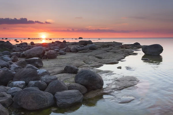 Západ slunce za skalnaté pobřeží — Stock fotografie