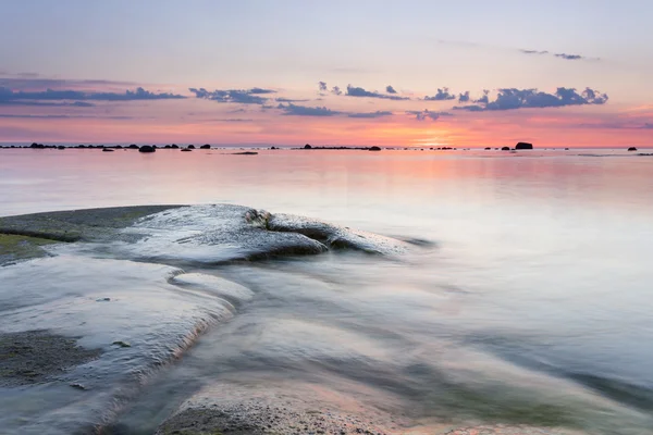 Pôr do sol atrás da costa rochosa — Fotografia de Stock