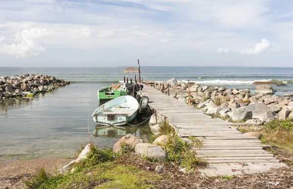 Старые рыболовные лодки в море, прикрепленные к мосту — стоковое фото