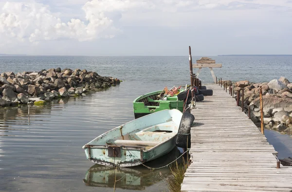 Antiguos barcos de remos de pesca en el mar unidos al puente —  Fotos de Stock