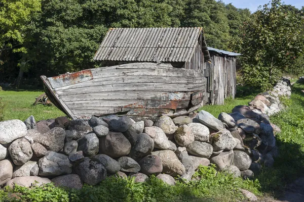 Oude gebroken hout boot in tuin — Stockfoto