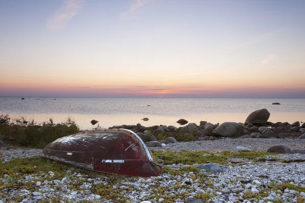 Красная лодка на закате — стоковое фото