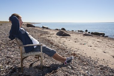 genç adam yaslanın ve rahatlayın plajda sandalye üzerinde