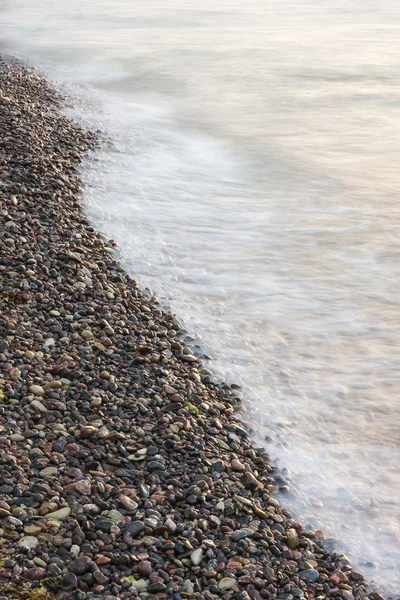 Sea waves on small rocks at seashore — Stock Photo, Image
