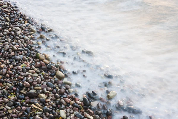 Sea waves on small rocks at seashore — Stock Photo, Image