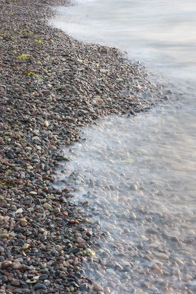 Sea waves on small rocks at seashore — Stock Photo, Image