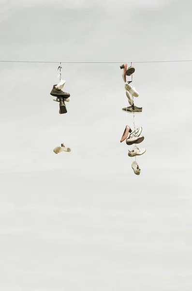 Eski yıpranmış çizme ya da ayakkabı bir kablo üzerinde asılı — Stok fotoğraf