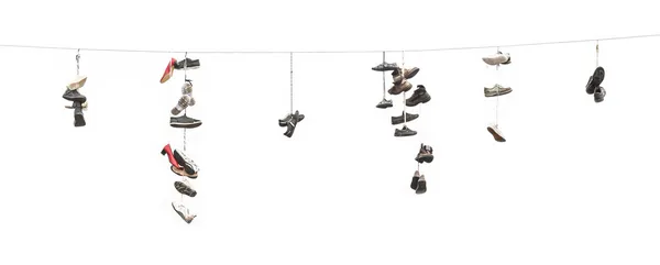 Oude versleten laarzen of schoenen hangen een kabel — Stockfoto
