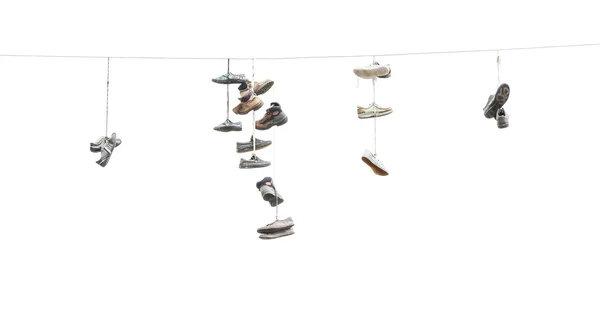 Oude versleten laarzen of schoenen hangen een kabel — Stockfoto