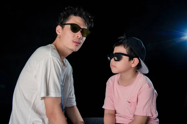 Man Och Liten Pojke Med Solglasögon Sitta Tittar Kamera Mörk — Stockfoto