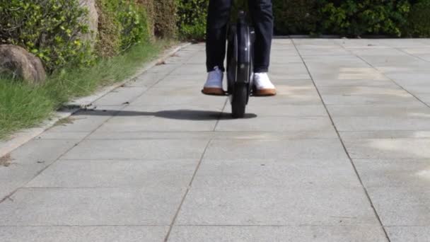 En man rider elektrisk enhjuling i stadsparken, framifrån — Stockvideo