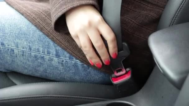 Weibliche Hand schnallt den Sicherheitsgurt im Auto in Großaufnahme an. — Stockvideo