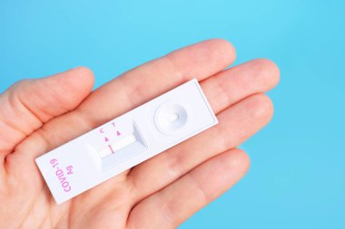 Mavi arka planda kadın eli için koronavirüs testi negatif..