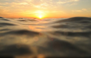 deniz üzerinde bulutlu gün batımı