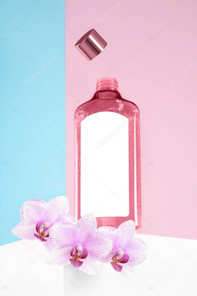 Mock up pink cosmetics bottle,open lid flying above,3 purple orchids flowers. Hero shot on white pedestal,organic still life advertised moisturizing toner,tonic on blue lilac.Mockup design.Copy space.