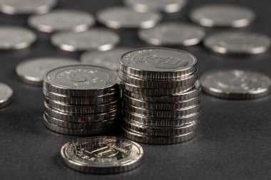 Ukrayna 10 hryvnias sikkesi. Para ve mali durum. Karanlık bir arka planda 10 tane Hryvnia madeni para yığını. Ukrayna paraları.