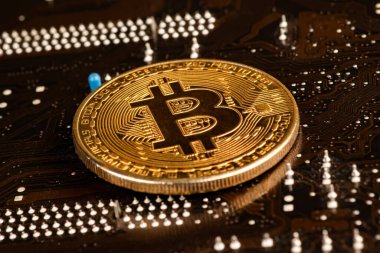 Üzerinde bitcoin sembolü olan altın sikkeler..