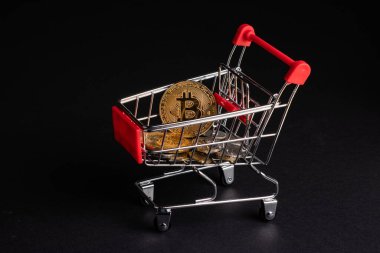 Bitcoin sanal para konsepti. Altın bitcoin dolu alışveriş arabaları koyu arkaplan.