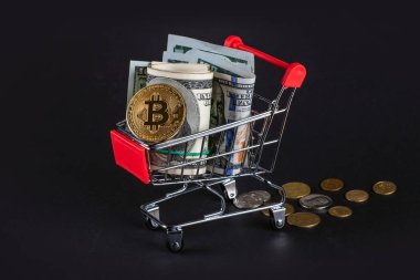 Bitcoin sanal para konsepti. Altın paralarla dolu alışveriş arabası ve koyu bir arka planda 100 dolar. Dökülmüş paralar.